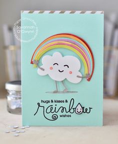 there is a card with a rainbow on it and a cloud in the middle that says hugs & kisses & rainbow wishes