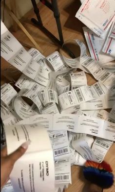 a pile of tickets sitting on top of a wooden floor next to a pair of scissors