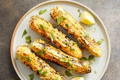 grilled corn on the cob with lemon wedges and mint garnish