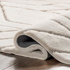 a close up of a white rug on a wooden floor