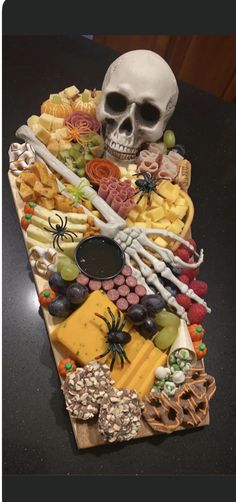 a halloween platter with a skull, bones, cheese and crackers on it