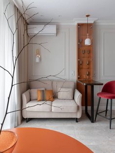 a living room filled with furniture next to a table and chair in front of a wall mounted air conditioner