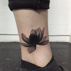 a black and white photo of a flower on the ankle, with its petals still attached