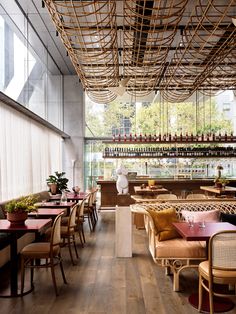 the inside of a restaurant with tables, chairs and hanging baskets on the ceiling above