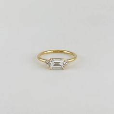 a gold ring with three stones on the side and a single stone in the middle