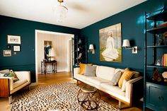 a living room with blue walls and white couches, leopard print area rugs