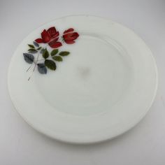 a white plate with red flowers on it