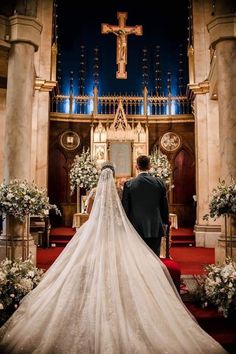 a bride and groom walking down the aisle at their wedding ceremony in front of an ornate alter