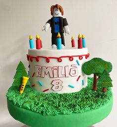 a birthday cake decorated with candles and a figure on top