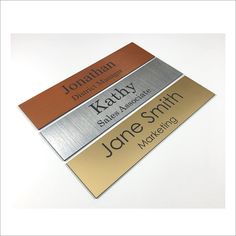 three metal name tags sitting on top of each other