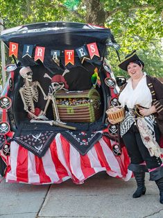 a woman in pirate costume standing next to an open trunk with skeleton decorations on it