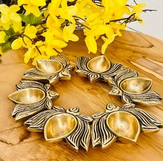 a wooden table topped with yellow flowers and metal dishes