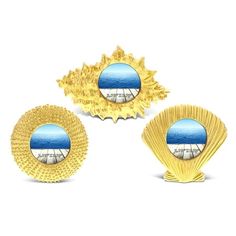 three pieces of gold and blue art deco broochies, each with an image of a beach scene