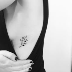 black and white photo of a woman's chest with a flower tattoo on it