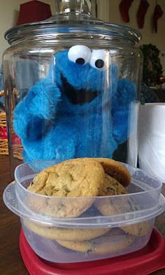 cookie cookies in plastic containers on top of a wooden table next to a cookie jar