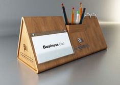 a wooden desk organizer with pens and pencils in it