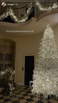 a white christmas tree sitting in the middle of a room