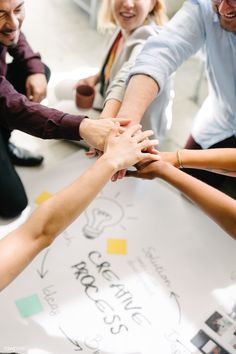 a group of people holding hands in the middle of a circle