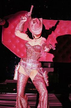 a woman dressed in pink is performing on stage