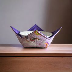 an origami boat sitting on top of a wooden table