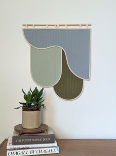 a potted plant sitting on top of a wooden table next to two bookends