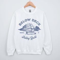 This sweatshirt is a must have for Below Deck Sailing Yacht. Celebrate Captain Glenn and the Parsifal Crew. Get one for the Yachtie in your life Ideal for any situation, a unisex heavy blend crewneck sweatshirt is pure comfort. These garments are made from polyester and cotton. This combination helps designs come out looking fresh and beautiful. The collar is ribbed knit, so it retains its shape even after washing. There are no itchy side seams on these sweaters.  .: 50% cotton, 50% polyester .: Crew Neck Graphic Print Top For Sailing, Nautical Cotton Sweater With Crew Neck, Nautical Cotton Crew Neck Sweater, Casual White Tops For Sailing, Casual White Top For Sailing, White Nautical Tops For Sailing, White Nautical Crew Neck Top, Bravo Tv, Below Deck