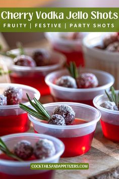 cherry vodka jello shots in plastic cups with rosemary sprigs on the side