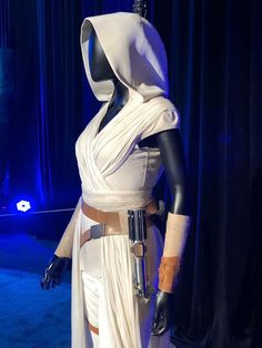 a star wars costume on display in front of a blue curtain with lights behind it