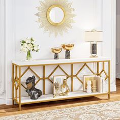 a white and gold console table with two vases on it, one is filled with flowers