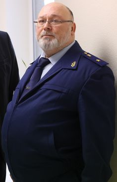 a man in uniform standing next to a wall