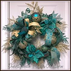 a wreath with green and gold decorations hanging on the front door for holiday decorating