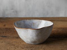 a white bowl sitting on top of a wooden table