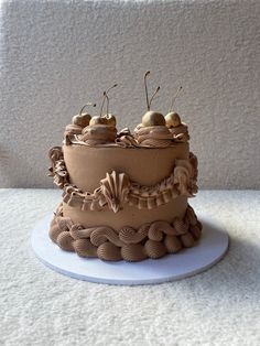 a chocolate cake with cherries on top sitting on a white table next to a wall