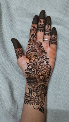 a woman's hand with henna tattoos on it