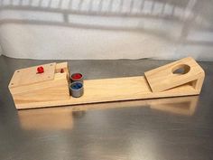 two wooden pegs are sitting on top of a metal surface and one is painted red