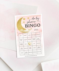 a pink and gold baby shower game on top of white envelopes with watercolor background