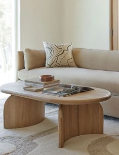 a living room with a couch, coffee table and pillows on the carpeted floor