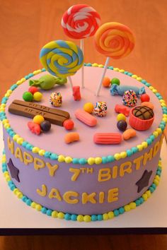 a birthday cake decorated with candies and lollipops