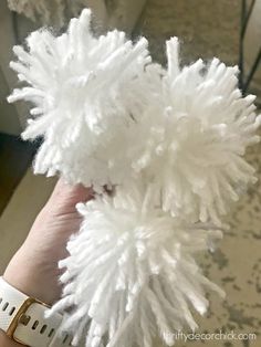 a person holding a white fluffy toy in their hand