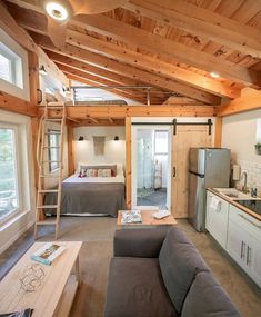 a living room filled with furniture next to a kitchen