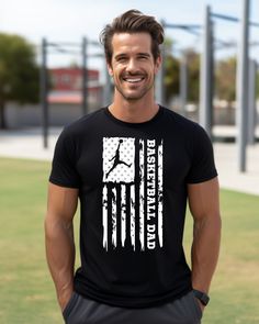 a man standing in front of a field wearing a black shirt with an american flag on it