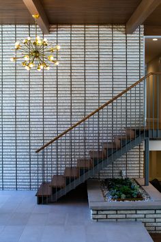 a room with stairs and a planter on the floor