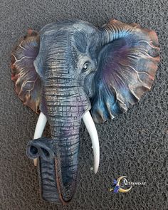 an elephant head with tusks is shown on the ground in front of a wall