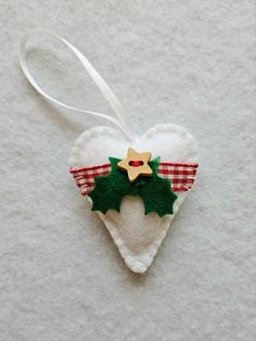 White felt Christmas Heart.  The perfect addition to your Christmas decorations. Cut from soft white felt, this heart has been hand stitched and decorated with red gingham ribbon, cut felt holly leaves and a wooden star button. White ribbon hanging loop. Measuring 6cm x 5cm and padded with hollow fibre filling. Price is for one heart only. Felt Holly, Christmas Heart, Felt Tree, Christmas Feeling, Holly Leaves, Heart Crafts