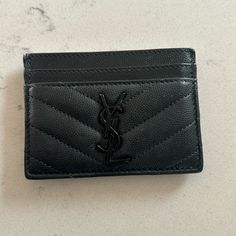 a black leather card holder with a monogrammed y on it