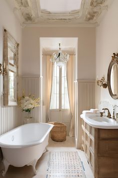 a bath room with a tub a sink and a mirror