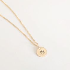 "This sweet paw print necklace is a beautiful keepsake for any pet lover! Dainty and delicate, it can be worn everyday and layered with other jewelry. You choose the number of discs. If one disc is chosen, it will be stamped with a paw print. If you choose to add additional discs with one initial on each, please leave initials in \"notes to seller\" box at checkout. DETAILS All components 14K gold fill (not plated)  9mm discs One initial per disc 18\" gold chain All discs are stamped by hand. Yo Round Pendant Necklace With Paw Print For Gift, Paw Print Round Pendant Jewelry As Gift, Paw Print Round Pendant Jewelry For Gift, Paw Print Round Pendant Jewelry Gift, Gold Paw Print Jewelry For Best Friend, Gold Paw Print Jewelry For Best Friend Gift, Gold Sterling Silver Jewelry With Paw Print, Gold Jewelry With Paw Print For Anniversary, Dog Lover Jewelry