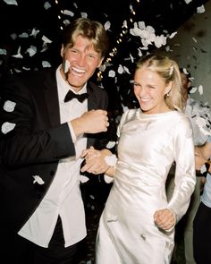 a man in a tuxedo standing next to a woman wearing a white dress