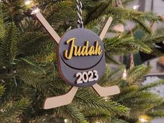 a christmas ornament hanging from a tree with hockey sticks and pucks on it