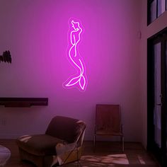 a room with a chair and a neon sign on the wall